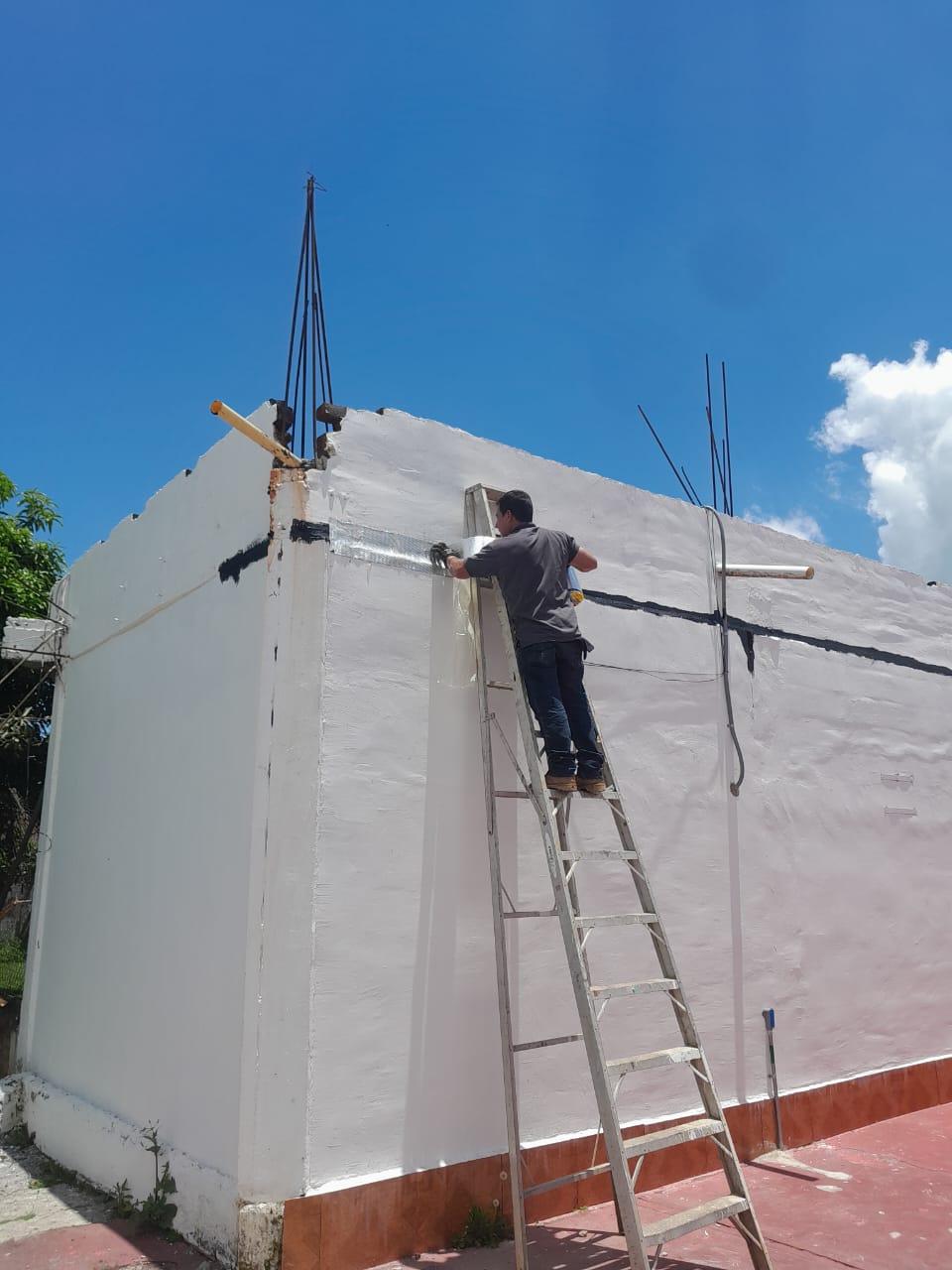 Ingeniero de INTICON reparando la corona de un muro sobre escalera